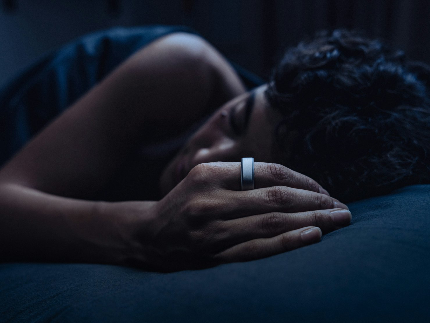 Woman sleeping soundly while wearing an Oura ring
