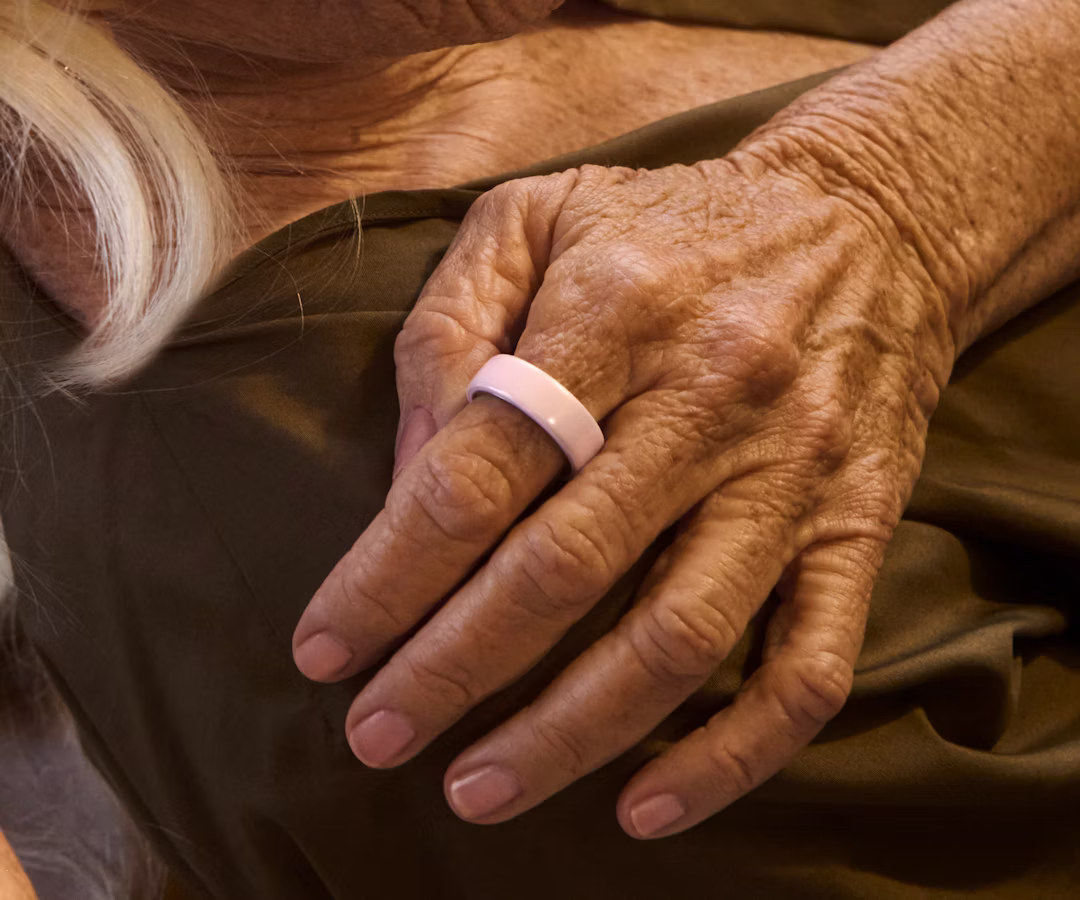 Close up of a person's hand with a Petal Oura Ring 4 Ceramic on their finger