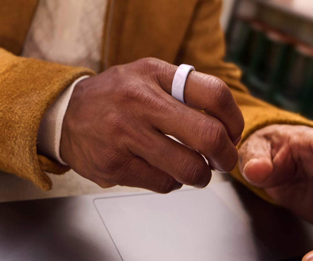 Close up of a person's hand with a Petal Oura Ring 4 Ceramic on their finger