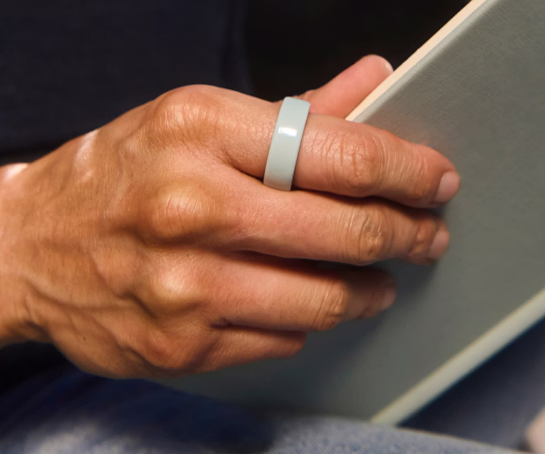 Close up of a person's hand with a Tide Oura Ring 4 Ceramic on their finger