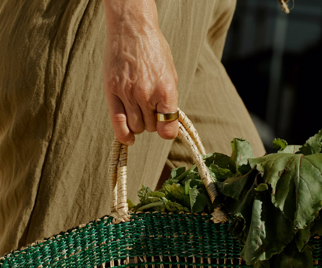 A person wearing a Gold Oura Ring 4 carrying groceries